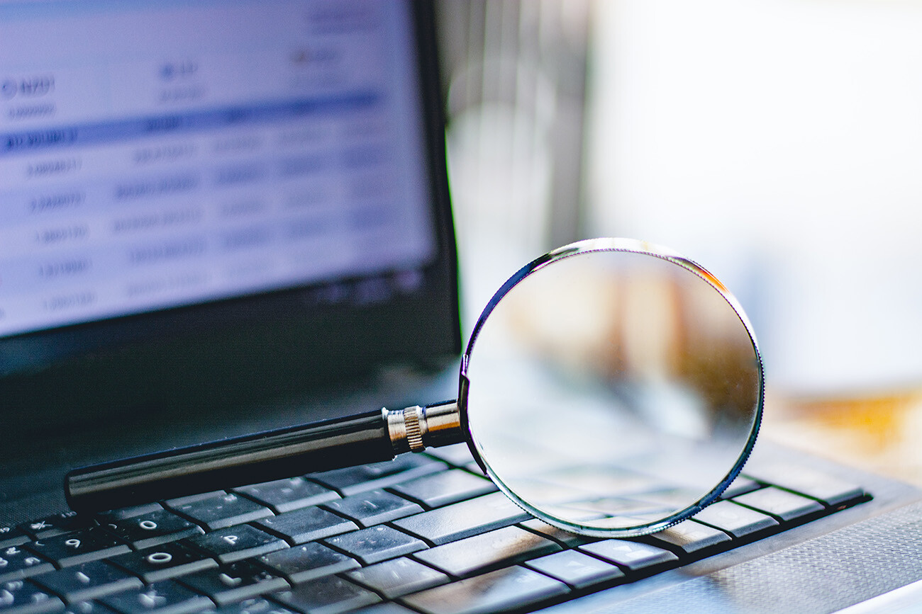 Magnifying glass resting on laptop keyboard