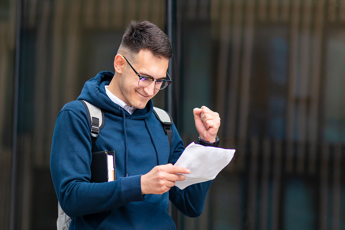 Man expressing excitement while reading a document he's holding