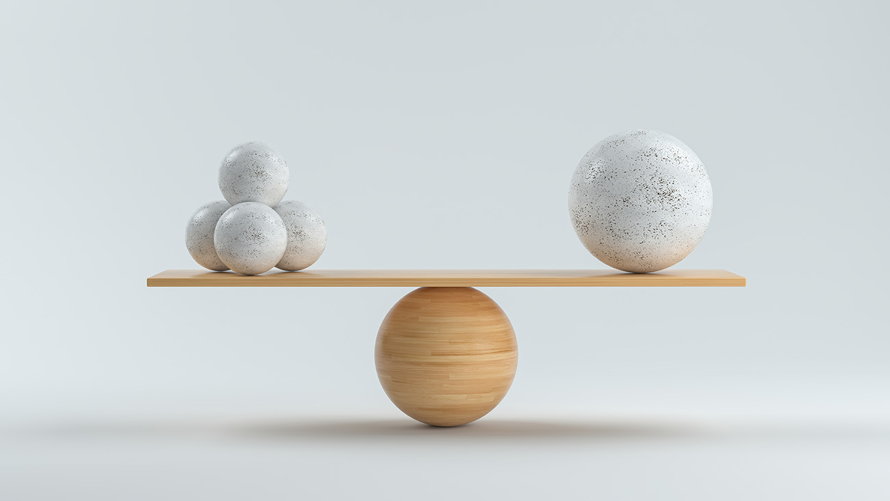 wooden scale balancing one large ball and smaller balls